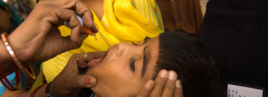 Bill Gates, co-founder of the Bill & Melinda Gates Foundation, gives a baby the oral polio vaccine